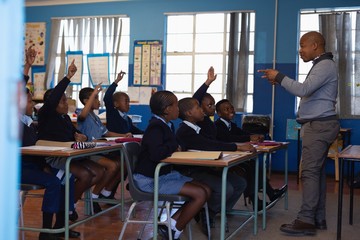 Male teacher teaching students in the classroom