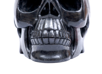Black realistic carved stone skull with Astrophyllite blades from Russia, isolated on white background.