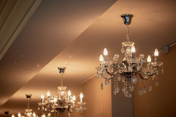 Several crystal chandeliers under the ceiling. Luxury and brilliance