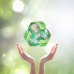 World environment day and ecology concept with woman human hands under green planet with recycle...