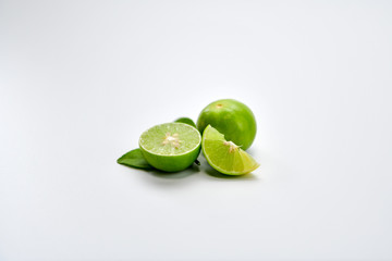 Lime fruit sliced and placed on white table.