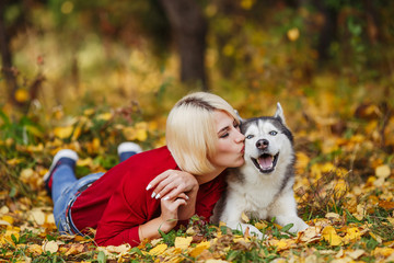 Beautiful caucasian girl plays with husky dog in autumn forest © hdesert