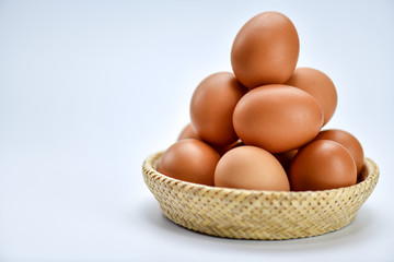 Brown eggs in the basket on a white background.