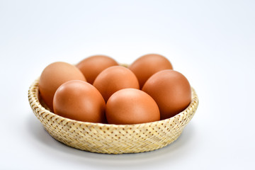 Brown eggs in the basket on a white background.