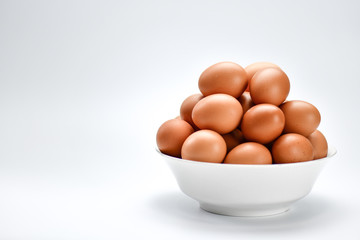 Close view of eggs in bowl on white background.