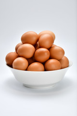 Close view of eggs in bowl on white background.