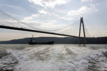 A big tanker passing by under the new bridge in Istanbul