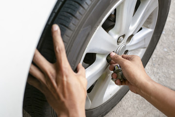 Obraz premium Hands of mechanic changing car wheel in auto repair service