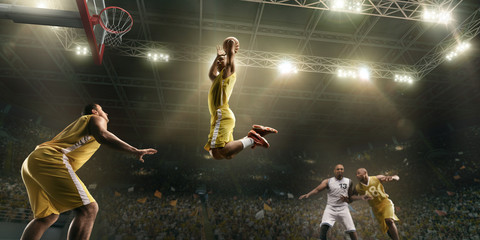 Basketball players on big professional arena during the game. Basketball player makes slum dunk © Alex