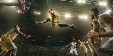 Basketball players on big professional arena during the game. Basketball player makes slum dunk © Alex