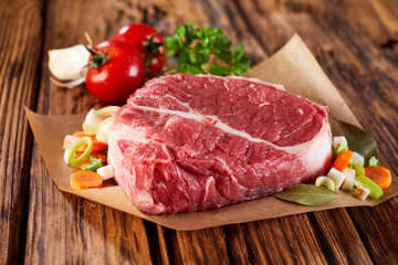 Piece of raw meat decorated with vegetables