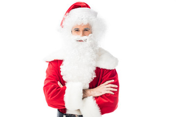 smiling santa claus in traditional costume standing with crossed arms isolated on white background