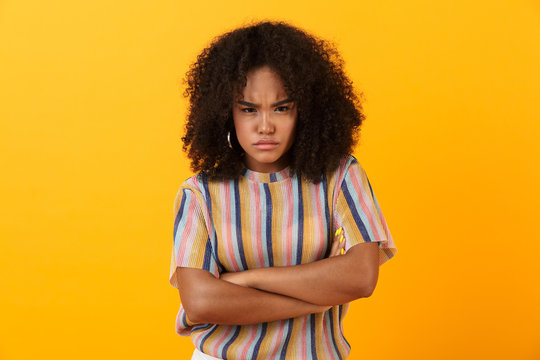 Displeased young african cute girl posing isolated over yellow background.