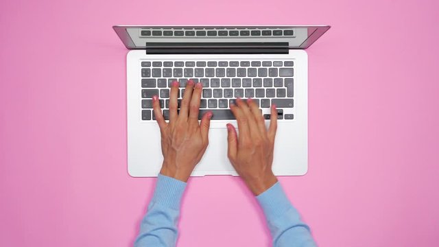 Woman hands typing on keyboard of silver laptop