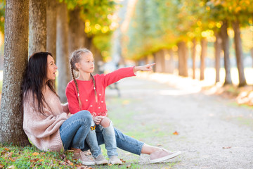 Fototapeta premium Family of mother and little kid outdoors in park at autumn day