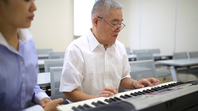 ピアノを習う高齢の男性