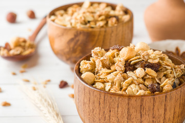 Dry Breakfast of oat flakes, granules and nuts. Muesli in a deep wooden plate.
