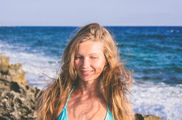 A woman with her hair loose in the wind on the background of the sea