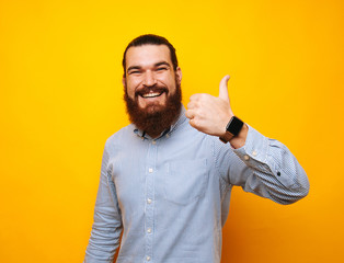 Happy bearded man in casual showing thumbs up