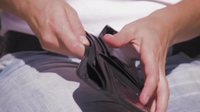 Bankruptcy. Empty wallet. A woman opens an empty wallet.