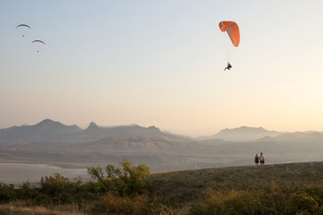 paraglider against the evening sky and mountain range