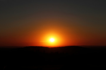 A horizontal beautiful orange sunset with black mountains