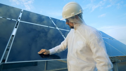 Male engineer cleans solar panel.