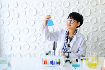 Fototapeta premium Scientists are working in laboratory. Young female researcher and her are doing investigations with test tubes.
