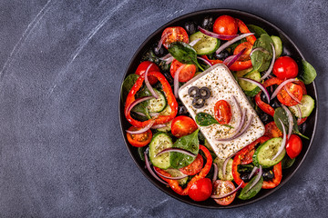 Greek salad of fresh cucumber, tomato, sweet pepper, spinach, red onion, feta cheese and olives