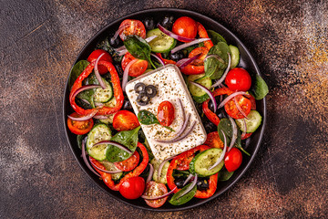 Greek salad of fresh cucumber, tomato, sweet pepper, spinach, red onion, feta cheese and olives