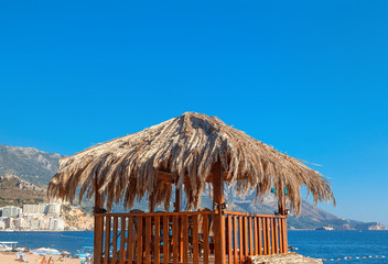 exotic gazebo covered by straw on the sunny beach 