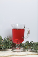 Blue spruce branches on a wooden box of boards, painted in white. Nearby is a glass of red wine.