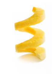 Rulo en espiral vertical de piña pelada sobre un fondo blanco