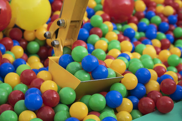 Toy metal excavator bucket with colorful plastic multi-colored balls
