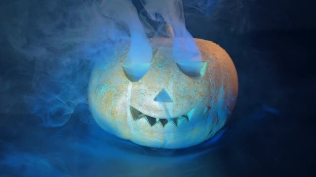 Terrifying pumpkin with smoke, close up.