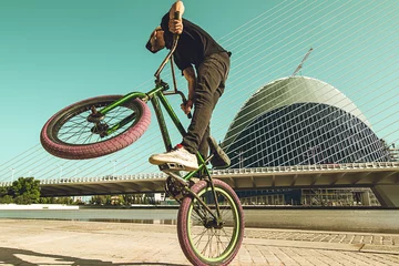 Guy tricking a bmx bike down the street © Rafa