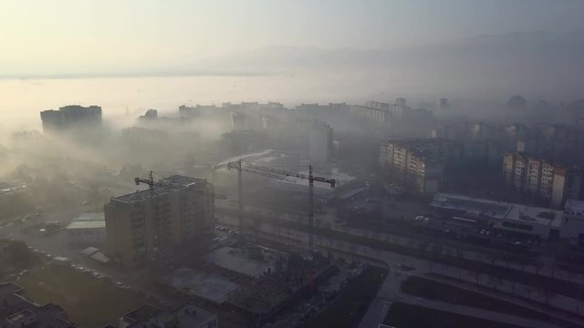 Flying over a concrete living apartment area in east Europa with many birds flying around the drone