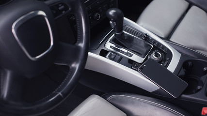 Plakat smartphone in the interior of a modern car