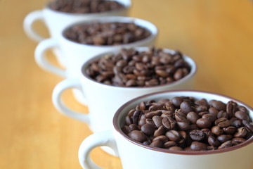 Full 4 cup of heap coffee bean on wooden table with copy space