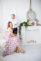 Wedding couple have a photo session in the amazing studio. Young couple hug and kiss while sitting...