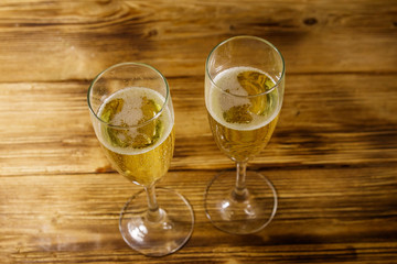 Two glasses of champagne on wooden table