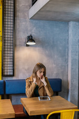 Portrait of a very pretty girl with a tablet in a cafe.