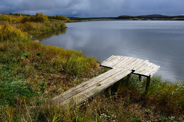 Shore of the lake and wooden walkway for fishing