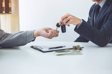 Salesman send key to customer after good deal agreement, successful car loan contract buying or selling new vehicle
