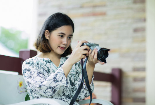 asian woman holding and checking photo from camera