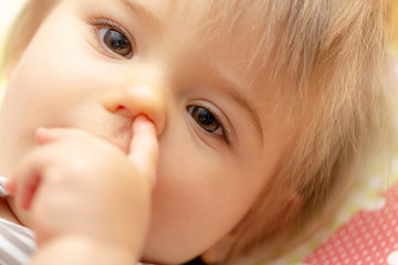 Children. Baby girl. Portrait. Finger. Nose