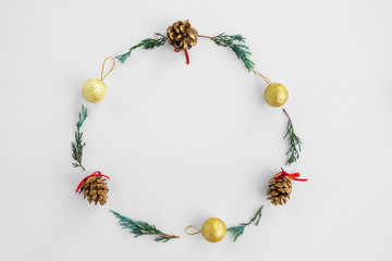 Christmas composition.  Christmas round frame made of pine cones, fir branches and golden balls on white background. Creative flat lay, top view design