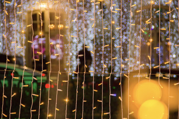 Coloured light bulbs. Christmas street decorations, new year preparation in city.Abstract blurry background