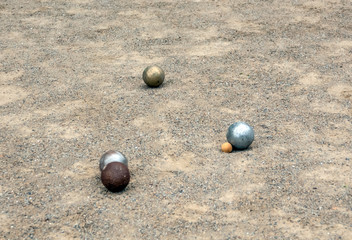 Balls of petanque on the sand during the game.