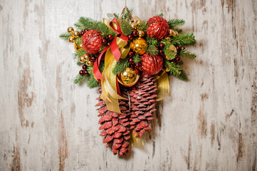 Christmas door decoration made of fir tree, red and golden glass balls and colored cones